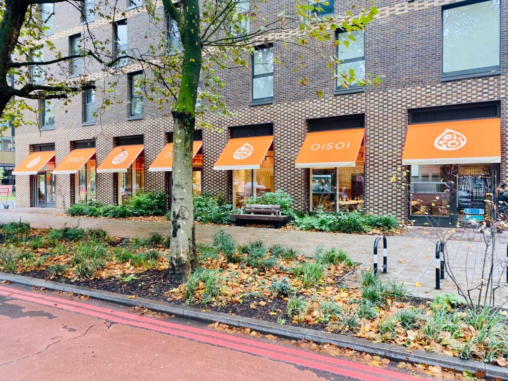 7 orange-coloured restaurant awnings in a row.